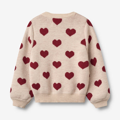 Jaquard Cardigan, Hearts, Merino Wool fra Wheat

Denne langærmede strikcardigan til børn er strikket i en dejlig blød uldkvalitet og har en behagelig, normal til let løs pasform.