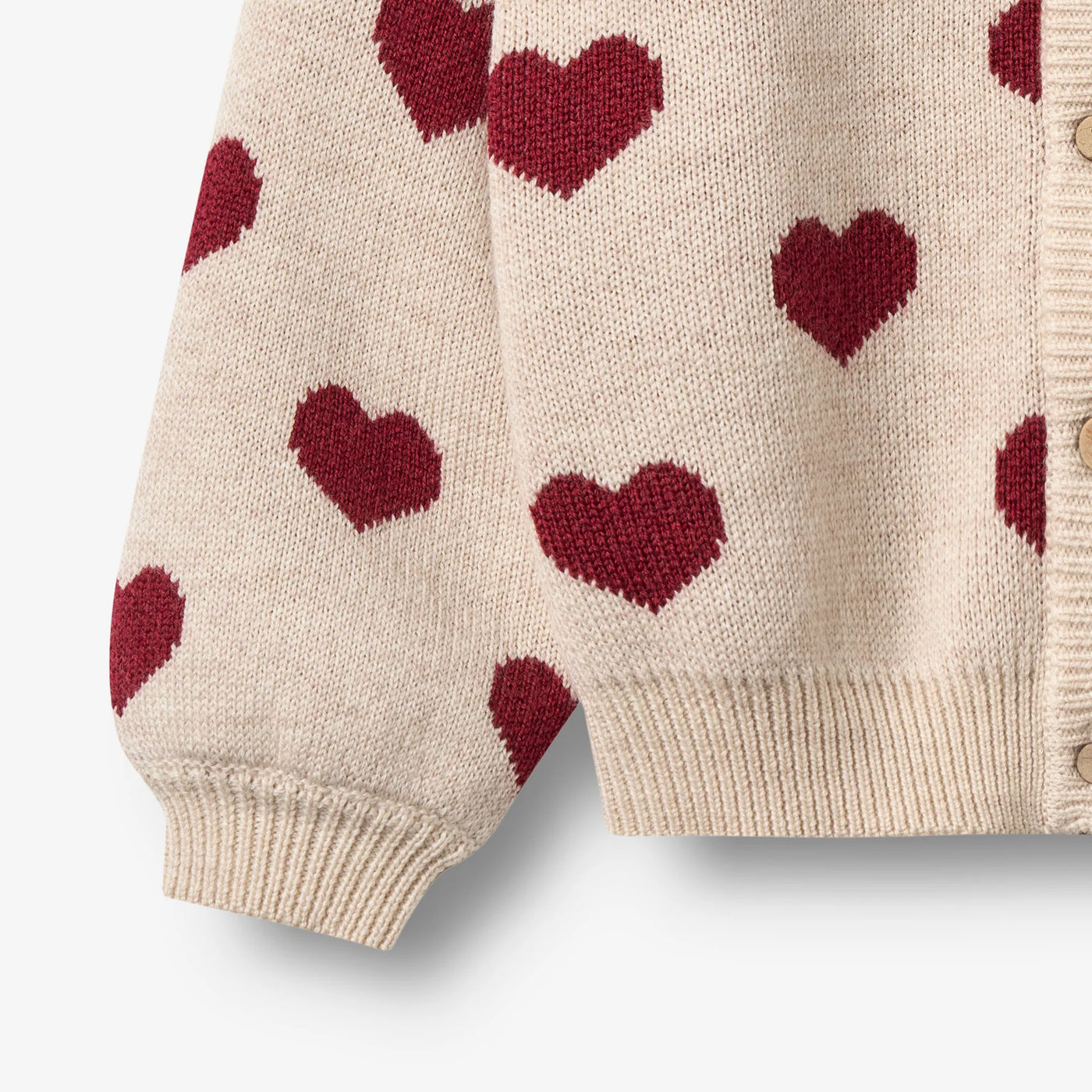 Jaquard Cardigan, Hearts, Merino Wool fra Wheat

Denne langærmede strikcardigan til børn er strikket i en dejlig blød uldkvalitet og har en behagelig, normal til let løs pasform.