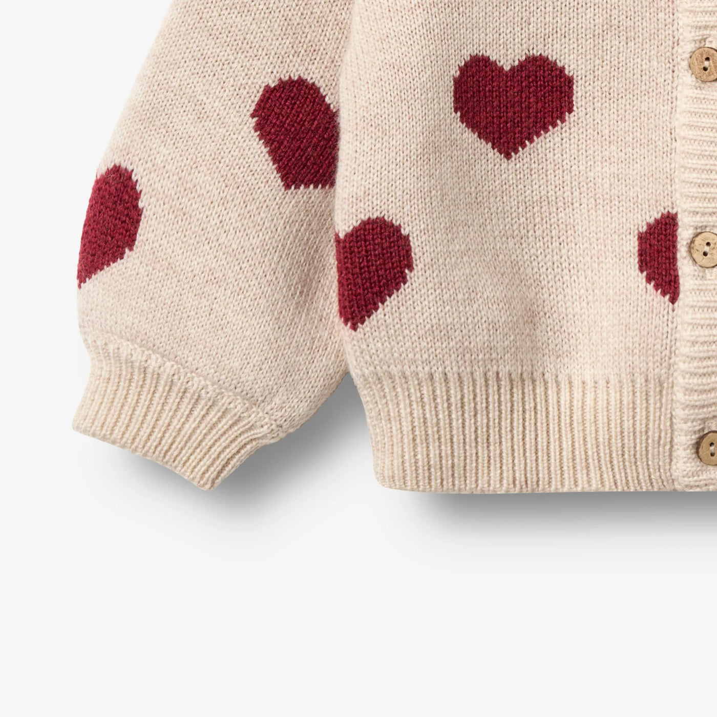 Jaquard Cardigan, Hearts, OffWhite, Merino Wool fra Wheat

Denne langærmede strikcardigan til børn er strikket i en dejlig blød uldkvalitet og har en behagelig, normal til let løs pasform. 