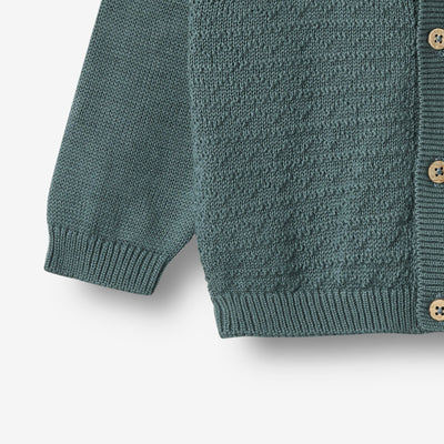 Strikket Cardigan, Bjørn, Stormy fra Wheat

Lækker langærmet strikcardigan i blød økologisk bomuld fra Wheat.